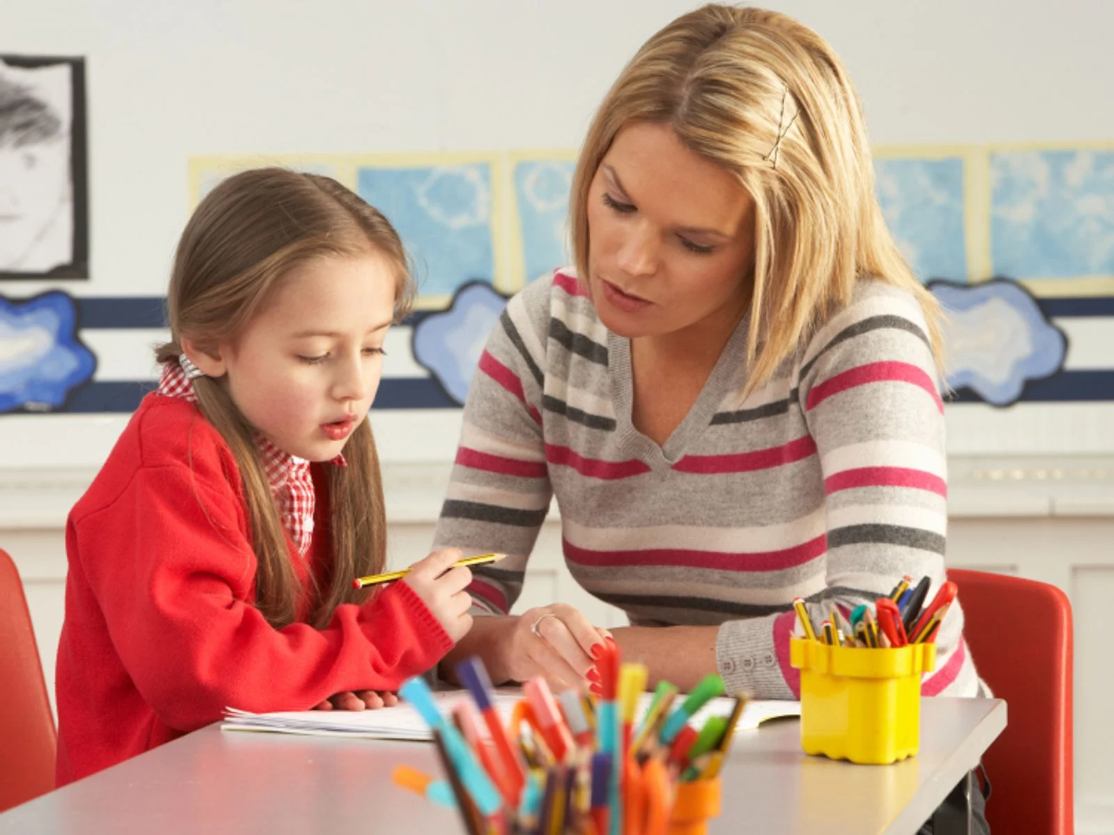 Young child learning at home with parent and teacher